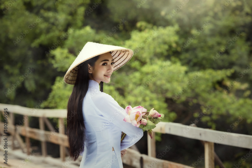 Vietnam Portrait beautiful woman in Ao Dai Traditional dress and holding lotus flower