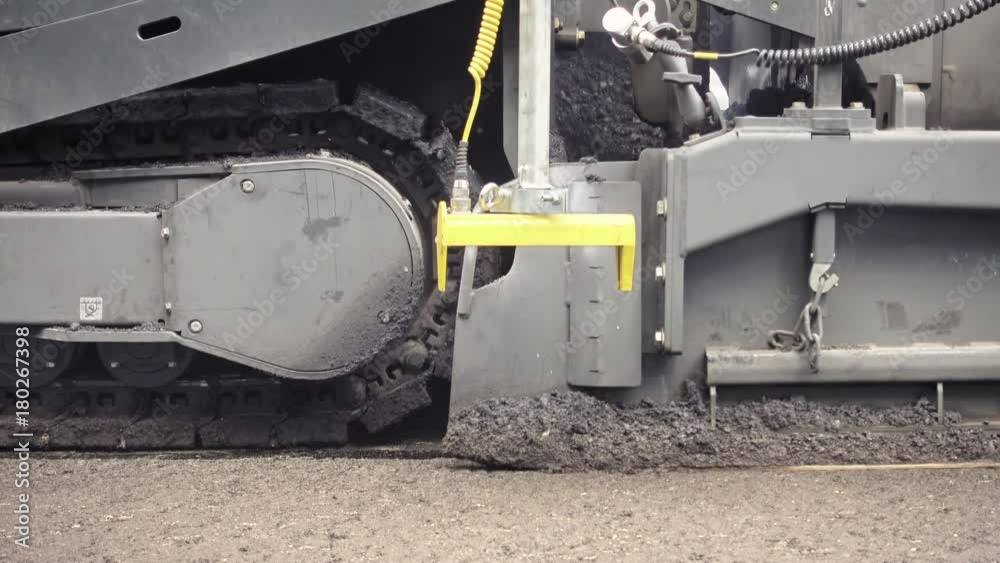 Road construction. Applying new hot asphalt using road construction machinery and power industrial tools. Roadworks repaving process. Road construction. Applying new hot asphalt using road construction machinery and power industrial tools. Roadworks repaving process.