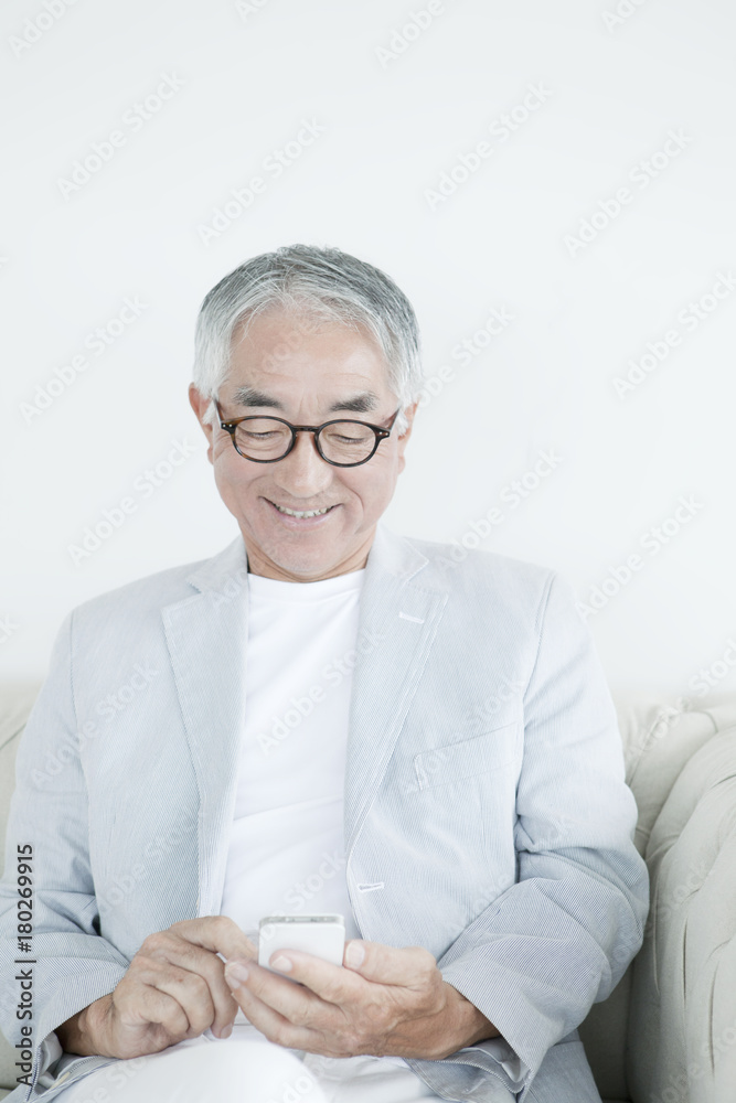 携帯電話を操作する中高年男性 携帯電話を操作する中高年男性
