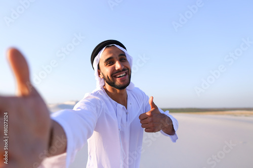 Happy portrait of male Arab who smiles and rejoices life, standi photo