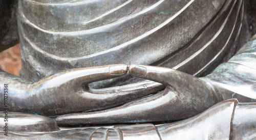 Detail of Buddha statue with Dhyana hand position, the gesture of meditation photo