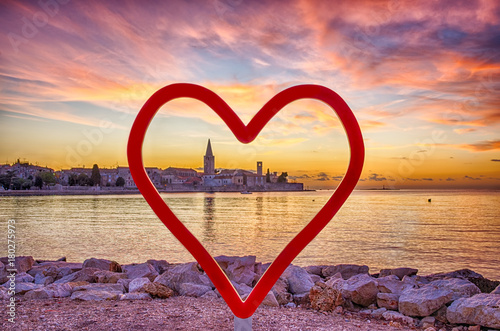 Adriatic coast sunset, Porec, Croatia.
Red heart shape as a love symbol against panoramic view of Porec, during sunset with cloudy sky. photo