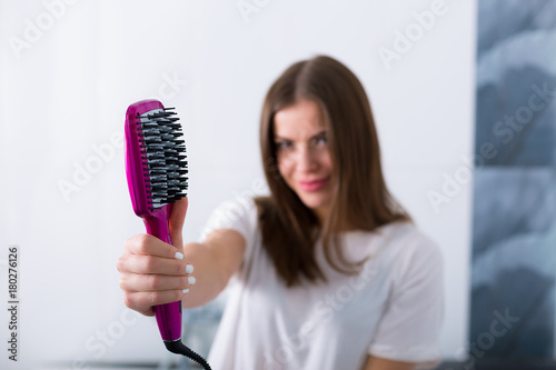 Woman with a hot straightening brush