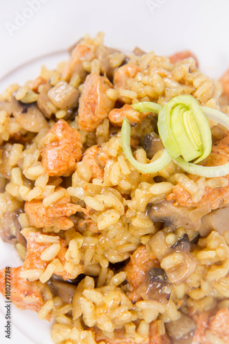 Risotto with mushrooms and chicken decorated with leek