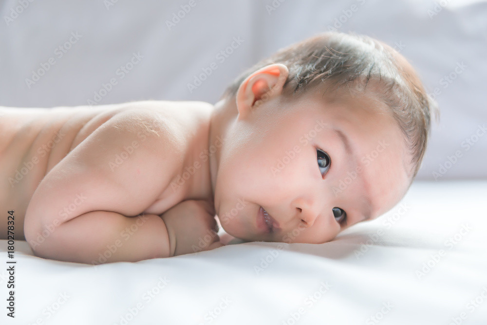 Cute asian baby lying on the bed from front angle Cute asian baby lying on the bed from front angle