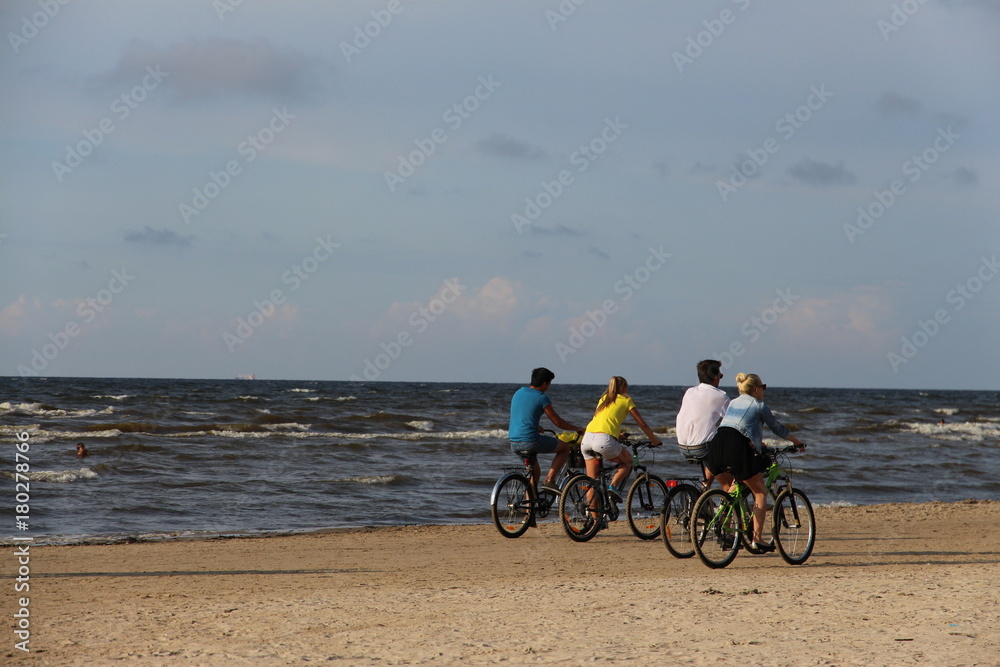 Obraz premium Two couples cycling along the Baltic sea shore in Jurmala, Latvia