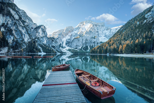 Klarer Gebirgssee mit Booten und Steg  vor felsiger Gebirgslandschaft  photo
