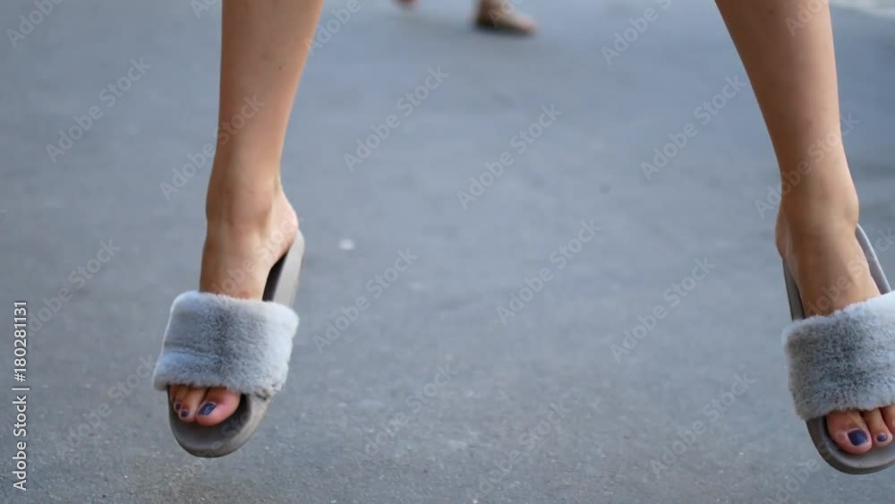 A girl is jumping in sneakers on the sidewalk. Close-up of female legs A girl is jumping in sneakers on the sidewalk. Close-up of female legs