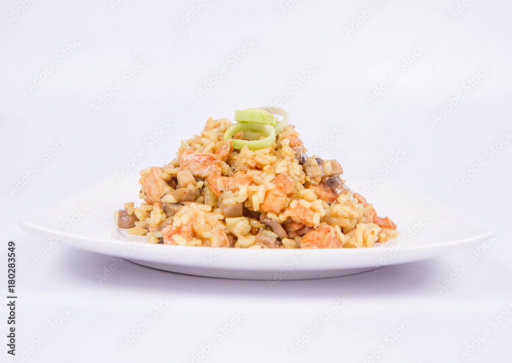 Risotto with mushrooms and chicken decorated with leek on a white background Risotto with mushrooms and chicken decorated with leek on a white background