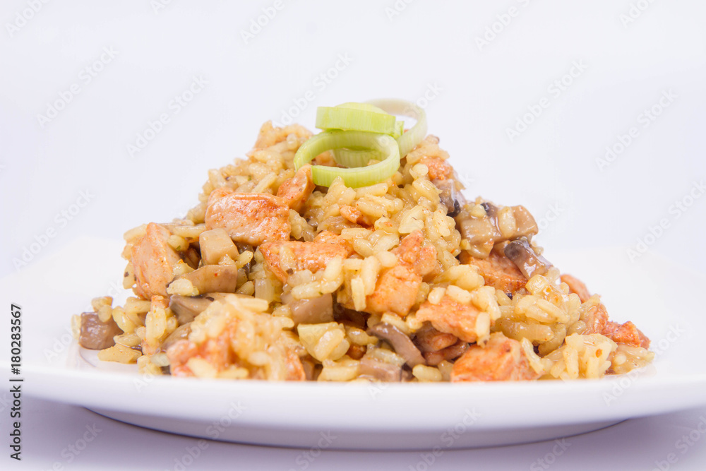 Risotto with mushrooms and chicken decorated with leek on a white background Risotto with mushrooms and chicken decorated with leek on a white background