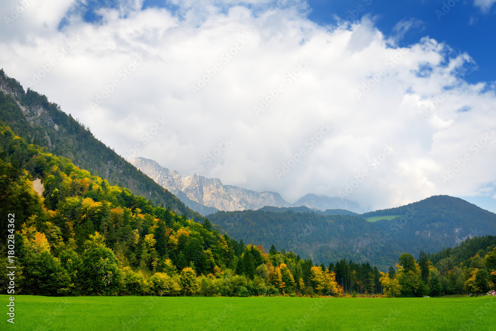 Fototapeta premium Breathtaking lansdcape of mountains, forests and small Bavarian villages in the distance. Scenic view of Bavarian Alps with majestic mountains in the background.
