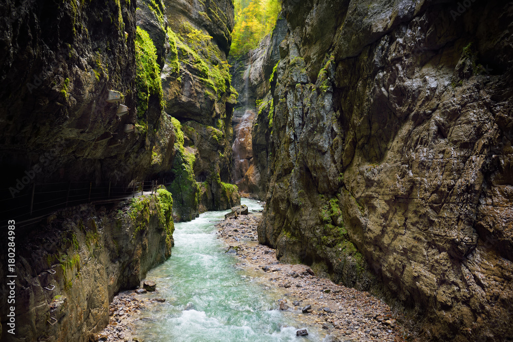 Blue water flowing in the Partnach Gorge or Partnachklamm, incised by a mountain stream in the Reintal valley near the town of Garmisch-Partenkirchen. Blue water flowing in the Partnach Gorge or Partnachklamm, incised by a mountain stream in the Reintal valley near the town of Garmisch-Partenkirchen.