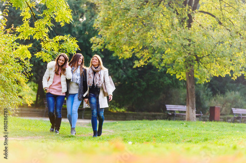 Three female friends walking in park
