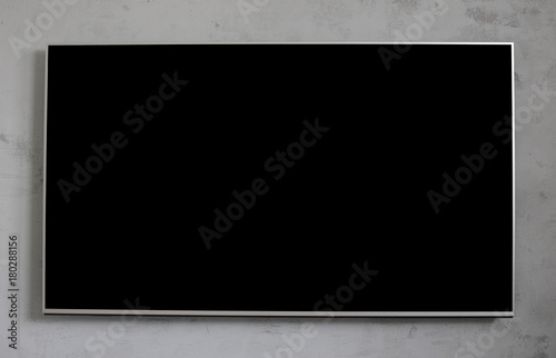 Empty black television screen on concrete wall