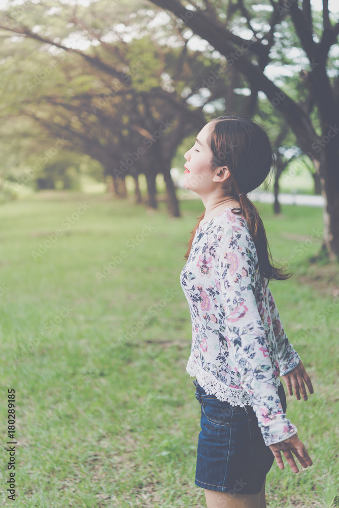 Fresh woman under tunnel trees with bright sunlight,Asian girl feel fresh,happy lady in the forest Fresh woman under tunnel trees with bright sunlight,Asian girl feel fresh,happy lady in the forest