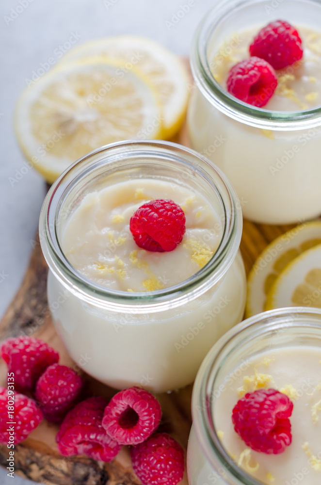 Lemon or vanilla curd in glass jars with raspberry and lemon sli Lemon or vanilla curd in glass jars with raspberry and lemon sli