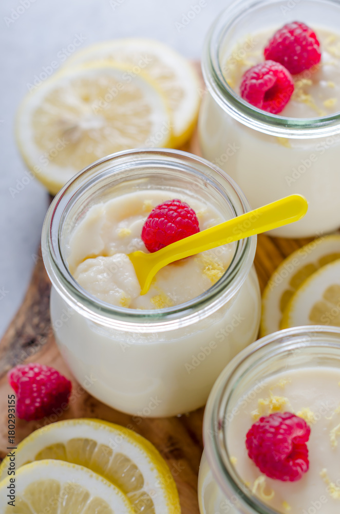 Lemon or vanilla curd in glass jars with raspberry and lemon sli Lemon or vanilla curd in glass jars with raspberry and lemon sli