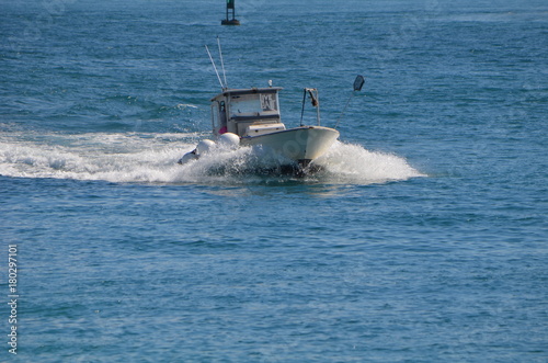 A boat selling live bait heading back to port to sell bait to charter fishing boat.