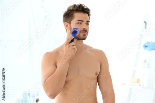 Handsome young man shaving ...
