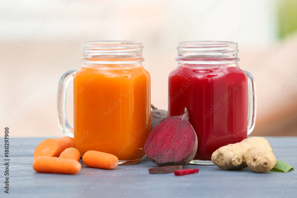 Mason jars with various fresh vegetable juices and ingredients on table Mason jars with various fresh vegetable juices and ingredients on table