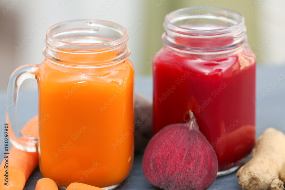 Mason jars with various fresh vegetable juices and ingredients on table Mason jars with various fresh vegetable juices and ingredients on table