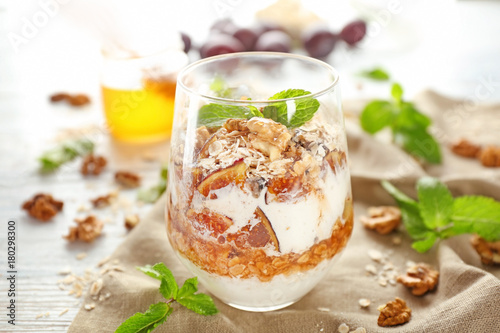 Delicious parfait with walnut and oatmeal in glass on table