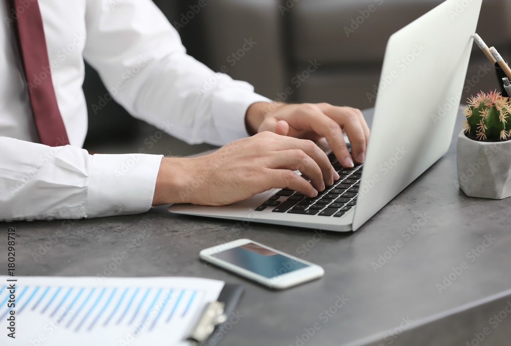 Businessman using his laptop while working in office Businessman using his laptop while working in office