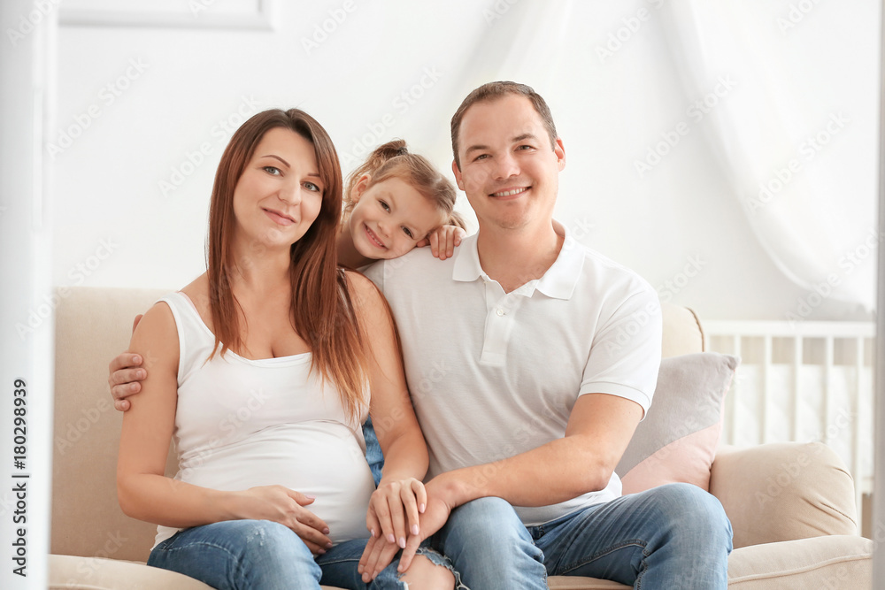 Happy young family on sofa at home