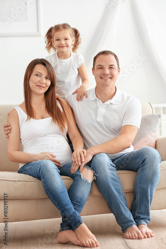Happy young family on sofa ...
