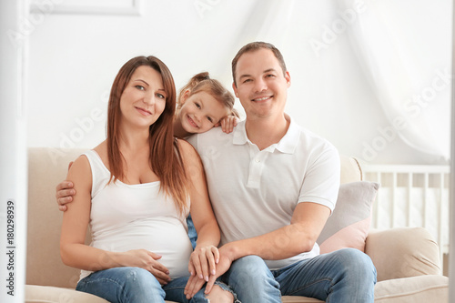 Happy young family on sofa ...