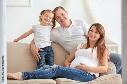 Happy young family on sofa at home