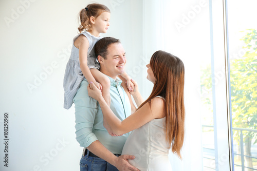 Happy young family near window