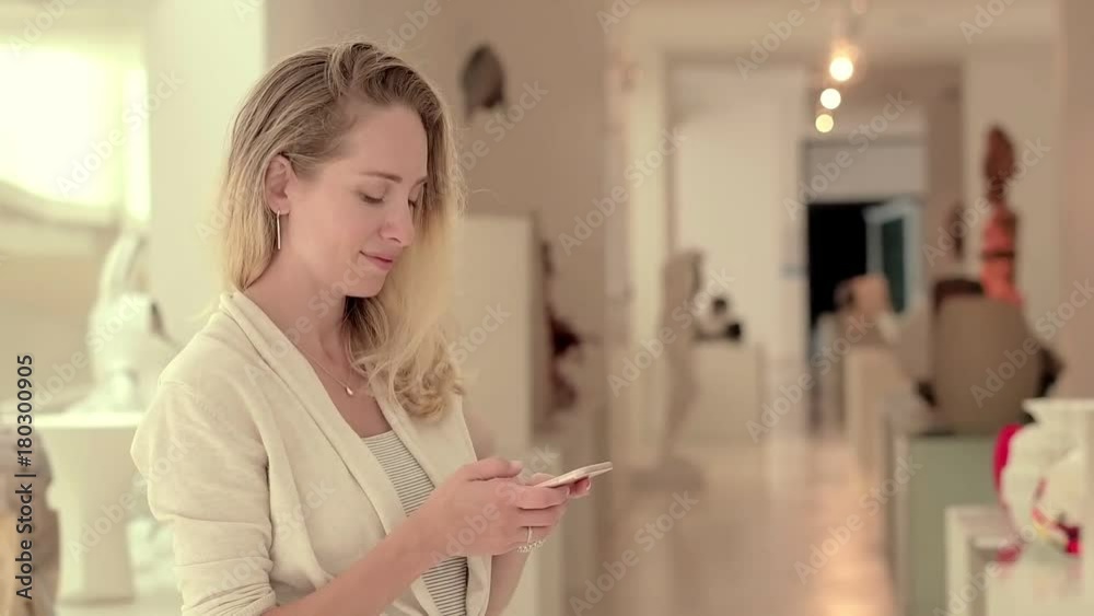 Beautiful woman using mobile for typing message on room background Beautiful woman using mobile for typing message on room background