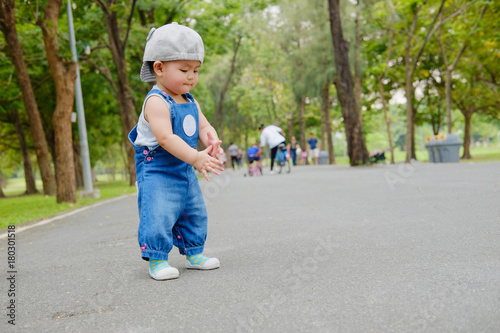 Asian Adorable baby girl playing in park. Beautiful smiling cute baby © uthaiphoto