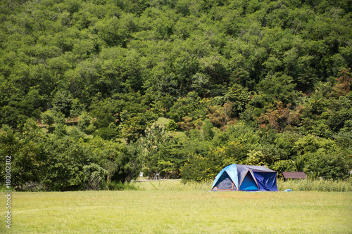 Travelers people build tent camping on grass field for rest and sleep near mountain at Chang Hua Man Royal Initiative and Agricultural Project