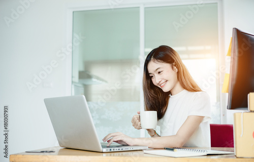 Young asian girl is freelancer with her private business at home office, working with laptop, coffee, online marketing, Customer order and packaging or packing.