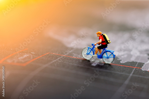 Miniature people  cycling on the world map. Travel, Sport and business concept. photo