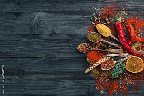 Fototapeta Naklejka Na Ścianę i Meble -  Spices and herbs. A large assortment of spices. Indian cuisine. On the wooden table. Top view. Free space for text.