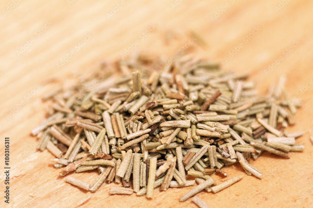 Heap of dried rosemary on a wooden background