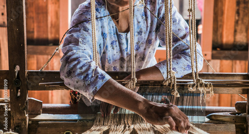 The local Intha woman weaving the lotus cloth with the hand loom at the local lotus cloth weaving factory in Inle lake, Shan State, Myanmar