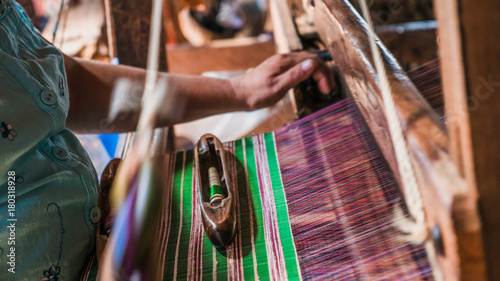 The local Intha woman weaving the lotus cloth with the hand loom at the local lotus cloth weaving factory in Inle lake, Shan State, Myanmar photo