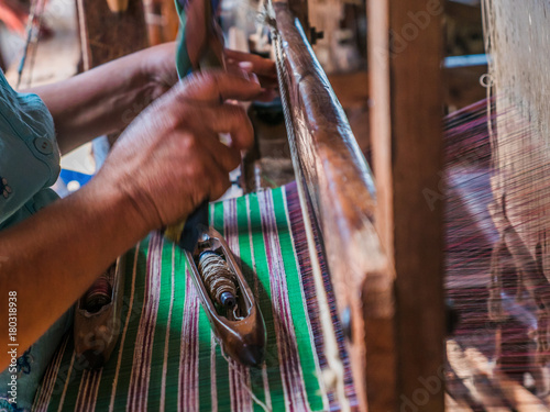 The local Intha woman weaving the lotus cloth with the hand loom at the local lotus cloth weaving factory in Inle lake, Shan State, Myanmar
