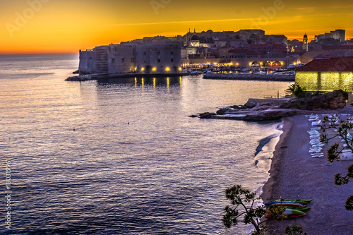 Dubrovnik cityscape sunset coastline. / Romantic sunset view over luxury travel resort in Croatia, Dubrovnik old town coastline view from beach Banje. photo