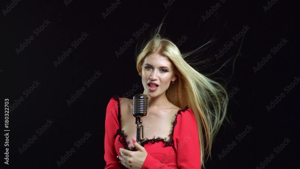 Girl in singing in retro microphone hilarious song. Black background Girl in singing in retro microphone hilarious song. Black background