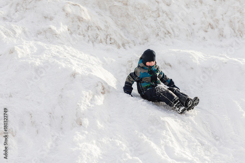 Small boy walking the mountain in deep snow