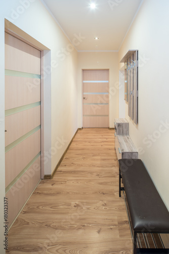 Corridor in the flat. Wooden hanger on the wall.