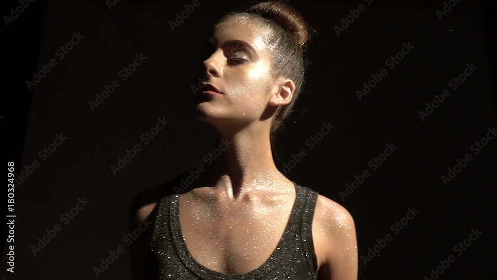 Brunette teenager in shines posing in the rays of light Brunette teenager in shines posing in the rays of light