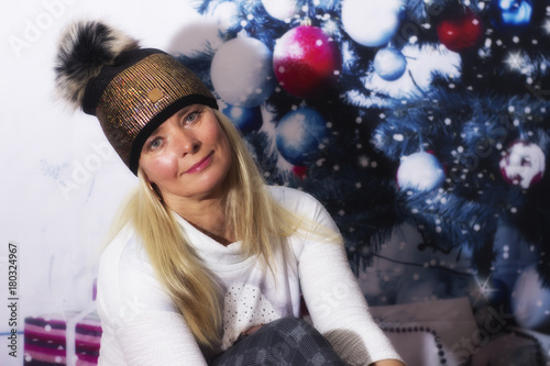 Middle age woman with santa cap on christmas background