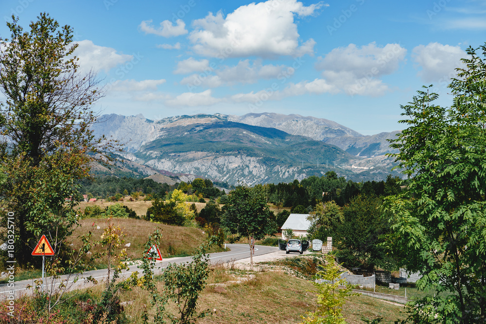 countryside road on a sunnyy day, mountains on the background