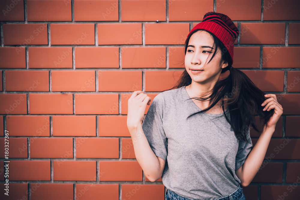 Portrait asian hipster girls on brick wall background,Hippie dress style,Thailand modern woman lifestyle,Beauty fashion portrait outdoor